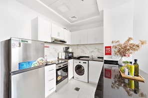 Una cucina moderna con forno integrato, microonde e lavatrice.