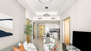 Een moderne woonkamer met een bank, een televisie en een eethoek op de achtergrond.