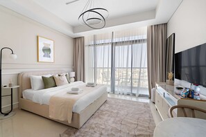 Ein modernes Hotelzimmer mit Bett, Schreibtisch, Fernseher und einem großen Fenster mit Vorhängen.