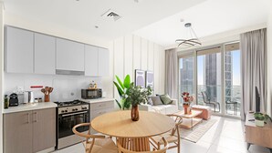 Eine moderne Küche mit Essbereich, ein großes Fenster mit Blick auf die Stadt und ein Balkon mit Stadtpanorama.