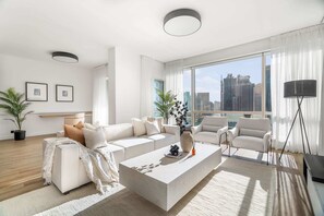 A modern living room with a large window, white furniture, and a city view. - Silkhaus Luxurious 3BR Maid Dubai Marina (Dubai)