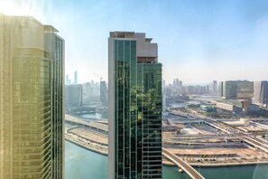 A high-rise building with a modern glass facade, surrounded by a cityscape and a river. - Silkhaus Cozy 1BR With Balcony Pool Gym on Reem Island (Abu Dhabi)