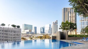 A swimming pool with a cityscape in the background. - Silkhaus Cozy 1BR With Balcony Pool Gym on Reem Island (Abu Dhabi)