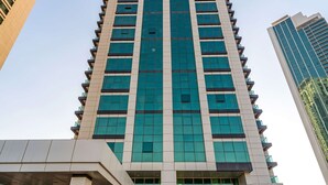 A tall, modern building with a glass facade and a prominent entrance. - Silkhaus Cozy 1BR With Balcony Pool Gym on Reem Island (Abu Dhabi)
