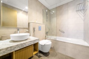 Een moderne badkamer met een marmeren wastafel, een toilet en een douchecabine.