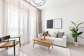 Ein modernes Wohnzimmer mit einer Couch, einem Holztisch, einer Bank und einer Topfpflanze.