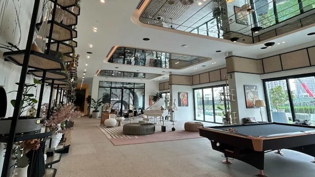 A spacious indoor area with a pool table, seating, and a staircase leading to an upper level. - Silkhaus Cozy 2 BR Full Amenities (Dubai)