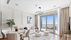 Une chambre d’hôtel moderne dotée d’un coin repas, d’une grande fenêtre offrant une vue agréable et d’un balcon.