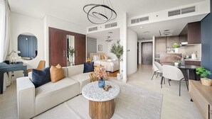 A modern living room with a sofa, coffee table, and dining area. - Silkhaus Cozy Studio Sky Gardens Heart of Difc (Dubai)