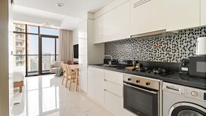 Una cocina moderna con un ventanal grande, comedor y lavadora.