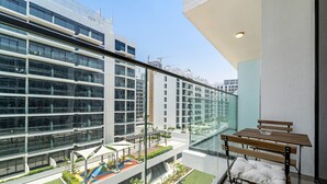 A modern apartment with a balcony, large windows, and a view of a cityscape. - Silkhaus Chic Studio Skyline View MBR City (Dubai)