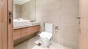 A modern bathroom with a toilet, sink, and mirror. - Silkhaus Chic Studio Skyline View MBR City (Dubai)