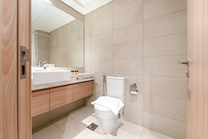Ein modernes Badezimmer mit Toilette, Waschbecken und Spiegel.