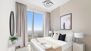 Een moderne hotelkamer met een groot bed, uitzicht op de stad en een minimalistische inrichting.