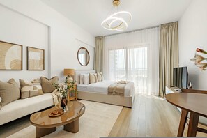 Et moderne hotelværelse med sofa, seng, spisebord og fjernsyn.