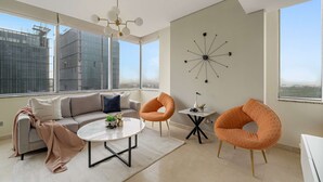Uma sala de estar moderna com um sofá, duas poltronas, uma mesa de centro e um relógio de parede.