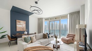 A modern living room with a sectional sofa, a coffee table, and a TV stand. - Silkhaus New 2bdr in Julphar Near Adgm (Abu Dhabi)