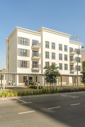 A multi-story hotel with a flat facade, balconies, and a covered entrance area. - Silkhaus Studio Getaway Yas Golf Collection (Abu Dhabi)