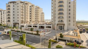 A modern residential building with multiple floors, balconies, and a central courtyard. - Silkhaus Premier 1BR Yas Golf Collection (Abu Dhabi)