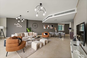 A modern living room with a sofa, armchairs, a coffee table, and a dining area with a table and chairs. - Silkhaus Expansive 2bdr in Sky Gardens Difc (Dubai)