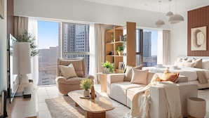 Een moderne woonkamer met een bank, fauteuils, een salontafel en een boekenkast.