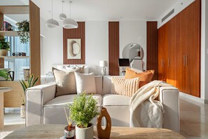Uma sala de estar moderna com um sofá, mesa de centro e plantas decorativas.