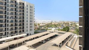 A multi-story residential building with balconies and a parking area with covered parking spaces. - Silkhaus Serene 1bdr Retreat in Yas Island (Abu Dhabi)