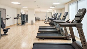 A gym with treadmills, weight machines, and a mirror wall. - Silkhaus Serene 1bdr Retreat in Yas Island (Abu Dhabi)