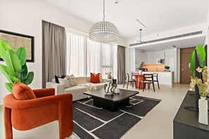A modern living room with a sofa, coffee table, and a dining area. - Silkhaus Elite 1bdr Canal Front Tower Al Wasl (Dubai)