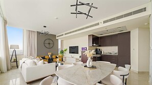 Ein modernes Wohnzimmer mit einem Marmorestisch, weißen Sofas und einer großen Wanduhr.