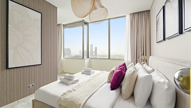 Ein modernes Hotelzimmer mit einem großen Bett, Blick auf die Stadt und einem großen Fenster.