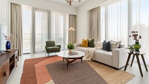 A modern living room with a sofa, coffee table, and a TV on a wooden cabinet. - Silkhaus Luxury 1BR Stay Canal Front in Al Wasl (Dubai)