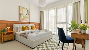 A modern hotel room with a large bed, a desk with a chair, a potted plant, and a large window with curtains. - Silkhaus Luxury 1BR Stay Canal Front in Al Wasl (Dubai)
