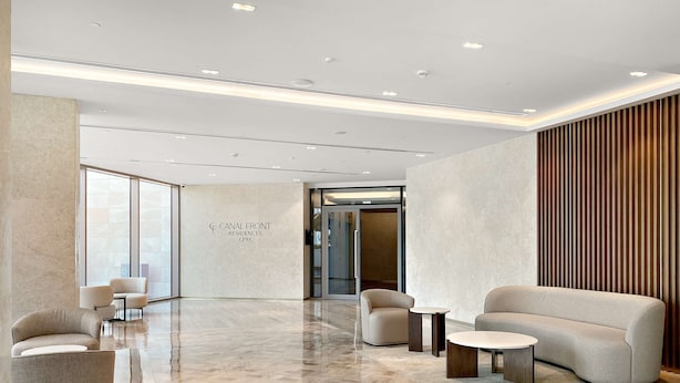 A modern lobby with a herringbone floor, seating areas, and a wall with the text "CANAL FRONT RESIDENCES CF9A". - Silkhaus Luxury 1BR Stay Canal Front in Al Wasl (Dubai)