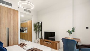 Een moderne hotelkamer met een bed, een televisie, een bureau en een stoel.