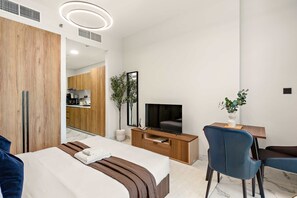 Ein modernes Hotelzimmer mit Bett, Fernseher, Schreibtisch und Stuhl.