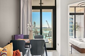 Ein modernes Hotelzimmer mit Balkon, Essbereich und Bett.