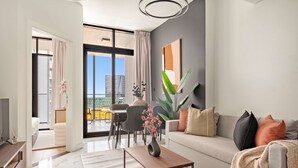 A modern living room with a sofa, coffee table, and a view of the cityscape through large windows. - Silkhaus 1bdr Prime Location in Maryah Island (Abu Dhabi)