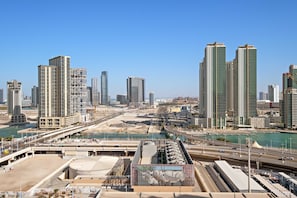 A cityscape with high-rise buildings, a river, and a bridge. - Silkhaus 1bdr Prime Location in Maryah Island (Abu Dhabi)