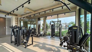 Een moderne sportschool met diverse fitnessapparaten, grote ramen en stadszicht.