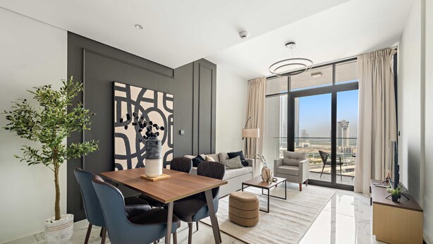 A modern living room with a dining area, a sofa, a coffee table, and a large window with a city view. - Silkhaus New 1bdr Living in Maryah Island (Abu Dhabi)