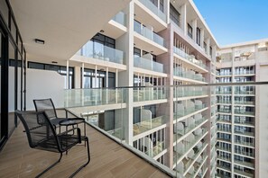A modern multi-story building with balconies, large windows, and a wooden floor. - Silkhaus Deluxe 1bdr Retreat in Maryah Island (Abu Dhabi)