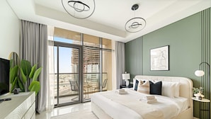 A modern hotel room with a large bed, a TV, a desk, and a balcony with a view of the city. - Silkhaus Cozy Studio High Floor Business Bay (Dubai)