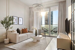 A modern living room with a sofa, coffee table, and a potted plant. - Silkhaus Modern 1 BDR Forte Tower Downtown (Dubai)