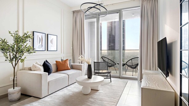 A modern living room with a sofa, coffee table, and a potted plant. - Silkhaus Modern 1 BDR Forte Tower Downtown (Dubai)