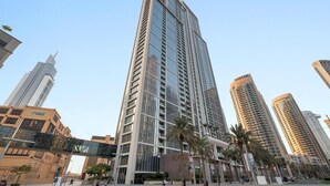 A tall, modern high-rise building with a glass facade and a prominent 'FOTIS' sign. - Silkhaus Modern 1 BDR Forte Tower Downtown (Dubai)