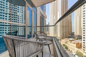 Varanda com mobiliário de vime e vista para edifícios altos.