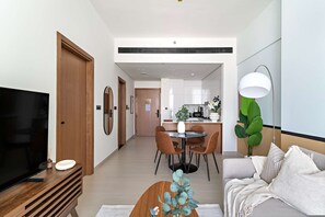 Ein modernes Wohnzimmer mit Flachbildfernseher, einer Holzunterhaltungsecke und einem runden Couchtisch mit einer Zierpflanze.