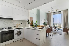 Eine moderne Küche mit Einbaugeräten, ein Essbereich mit Aussicht und ein großes Fenster.