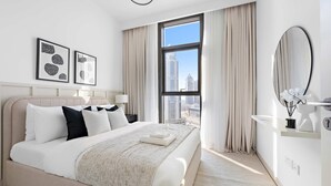 Ein modernes Hotelzimmer mit großem Bett, Blick auf die Stadt und minimalistischer Einrichtung.